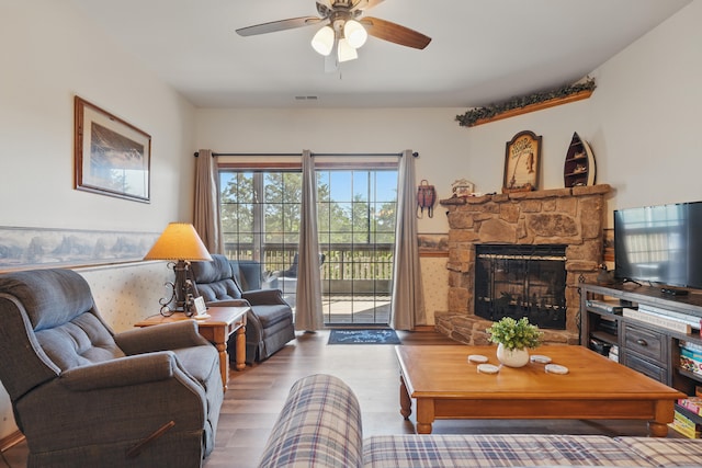 24 Village Trl Unit 13-2, Branson, MO 65616 - living area featuring wood finished floors, ceiling fan, and a stone fireplace