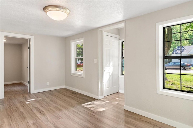 741 N Warren Ave, Springfield, MO 65802 - unfurnished room featuring light wood-style floors, baseboards, and a textured ceiling