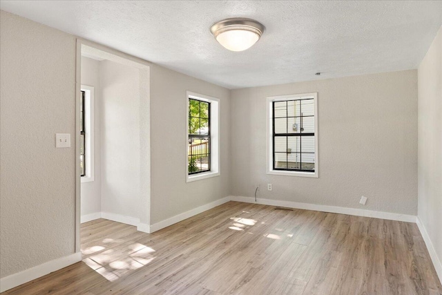 741 N Warren Ave, Springfield, MO 65802 - unfurnished room featuring light wood-style floors, a textured ceiling, baseboards, and a textured wall