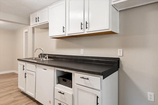 741 N Warren Ave, Springfield, MO 65802 - kitchen featuring white dishwasher, a sink, dark countertops, light wood-style flooring, and white cabinets