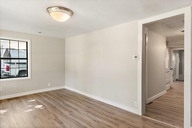 741 N Warren Ave, Springfield, MO 65802 - unfurnished room with wood finished floors, baseboards, and a textured ceiling