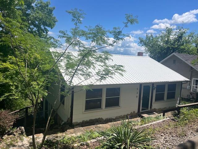 530 Taneycomo Hill Dr, Hollister, MO 65672 - view of front of house featuring a chimney and metal roof