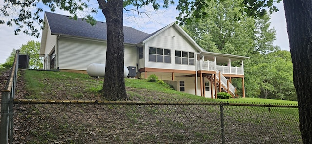 150 Licaria Rd, Ozark, MO 65721 - rear view of house featuring stairway, a fenced backyard, a wooden deck, roof with shingles, and a sunroom