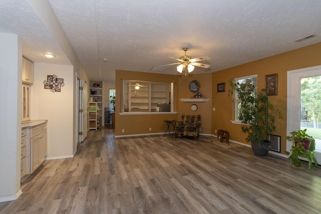 150 Licaria Rd, Ozark, MO 65721 - unfurnished living room with a textured ceiling, wood finished floors, and a ceiling fan