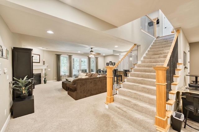 3262 S Thornridge Dr, Springfield, MO 65809 - carpeted living area with a glass covered fireplace, stairs, baseboards, a ceiling fan, and recessed lighting