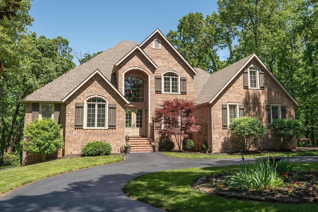 3262 S Thornridge Dr, Springfield, MO 65809 - traditional-style house featuring brick siding, roof with shingles, french doors, and a front lawn