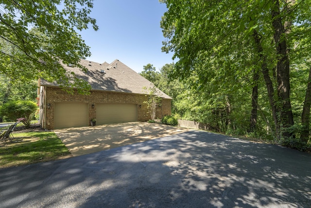 3262 S Thornridge Dr, Springfield, MO 65809 - view of side of home with asphalt driveway, brick siding, an attached garage, and a shingled roof