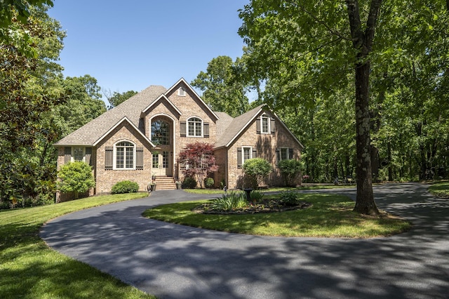 3262 S Thornridge Dr, Springfield, MO 65809 - view of front of house featuring brick siding, curved driveway, a front lawn, and roof with shingles