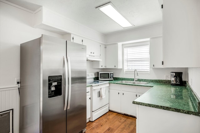 332 E Silsby St, Springfield, MO 65807 - kitchen with appliances with stainless steel finishes, under cabinet range hood, dark countertops, a sink, and white cabinets