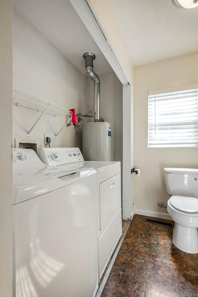332 E Silsby St, Springfield, MO 65807 - laundry area with washing machine and dryer, water heater, baseboards, and dark stone finish flooring