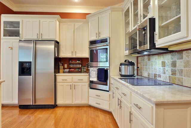607 Sumac Ln, Marshfield, MO 65706 - kitchen featuring stainless steel appliances, crown molding, light wood-style flooring, backsplash, and glass insert cabinets