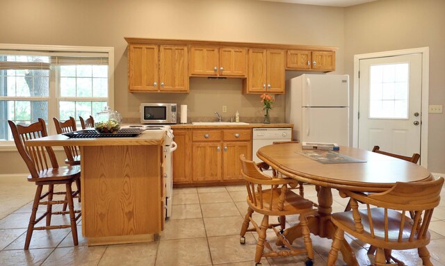 607 Sumac Ln, Marshfield, MO 65706 - kitchen featuring white appliances, a sink, a kitchen island, light countertops, and light tile patterned floors