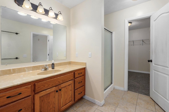 259 Aven Ave, Sparta, MO 65753 - full bathroom with vanity, a shower stall, a spacious closet, and tile patterned flooring