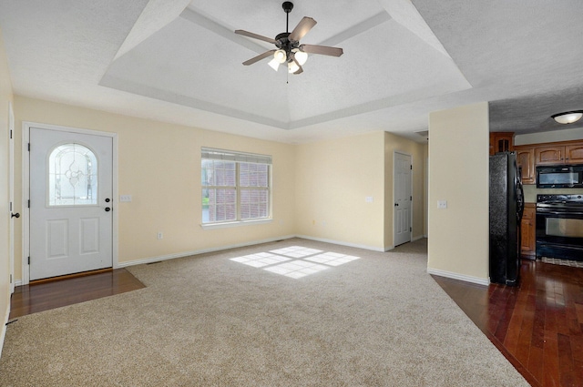 259 Aven Ave, Sparta, MO 65753 - foyer entrance featuring a tray ceiling, a ceiling fan, dark colored carpet, and dark wood-style floors