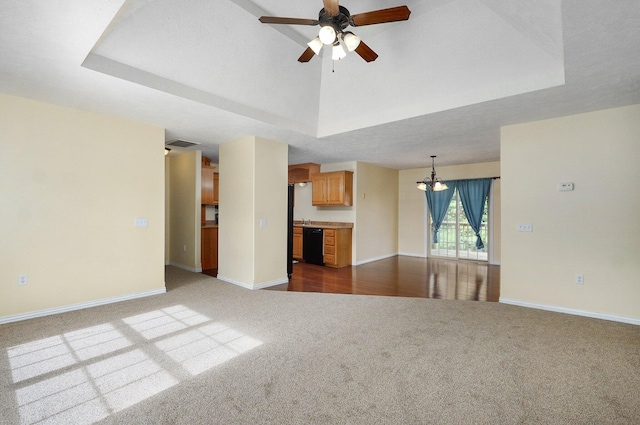 259 Aven Ave, Sparta, MO 65753 - unfurnished living room with dark colored carpet, a chandelier, a ceiling fan, and a tray ceiling