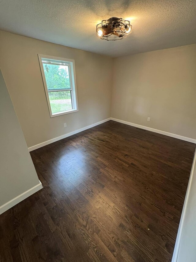 8574 County Road 6890, West Plains, MO 65775 - spare room featuring dark wood-style floors, baseboards, and a textured ceiling