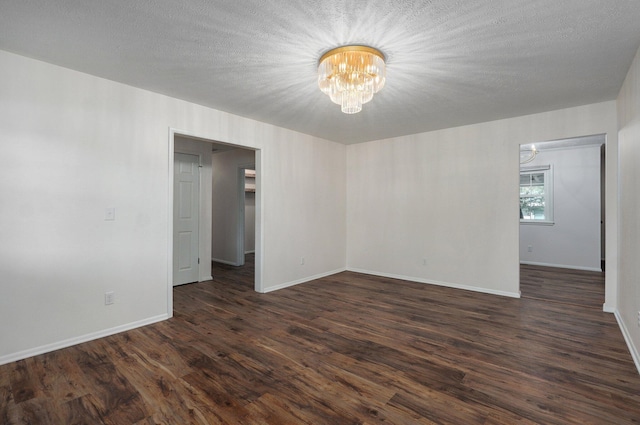 2411 S Rogers Ave, Springfield, MO 65804 - unfurnished room with a chandelier, dark wood finished floors, and baseboards