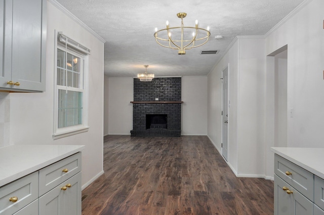 2411 S Rogers Ave, Springfield, MO 65804 - kitchen with a chandelier, light countertops, dark wood-type flooring, baseboards, and a textured ceiling
