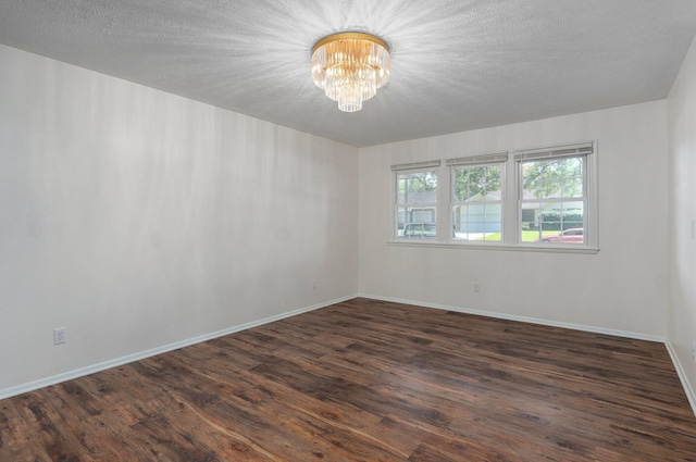 2411 S Rogers Ave, Springfield, MO 65804 - unfurnished room featuring a chandelier, dark wood finished floors, and baseboards