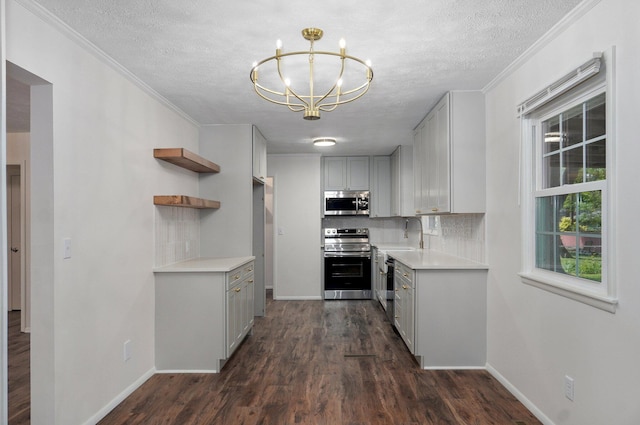 2411 S Rogers Ave, Springfield, MO 65804 - kitchen featuring appliances with stainless steel finishes, a chandelier, gray cabinetry, backsplash, and a textured ceiling