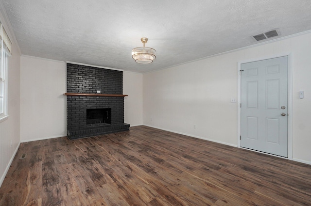 2411 S Rogers Ave, Springfield, MO 65804 - unfurnished living room with wood finished floors, crown molding, a textured ceiling, a brick fireplace, and baseboards