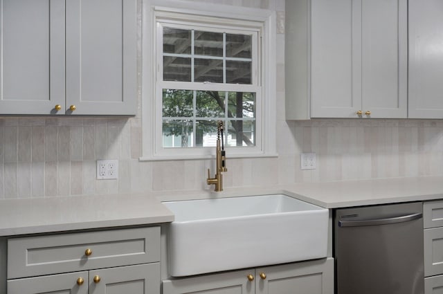 2411 S Rogers Ave, Springfield, MO 65804 - kitchen featuring dishwasher, a sink, decorative backsplash, light countertops, and gray cabinets