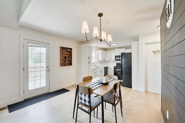 317 Cinnamon Ct, Sparta, MO 65753 - dining space featuring light wood-type flooring, a chandelier, and baseboards