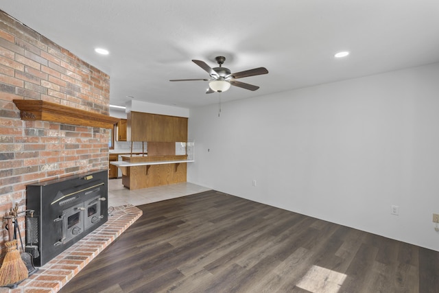 824 Highland Dr, Aurora, MO 65605 - unfurnished living room with a wood stove, wood finished floors, a ceiling fan, and recessed lighting