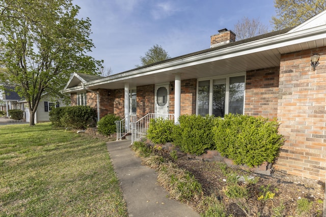 824 Highland Dr, Aurora, MO 65605 - view of front of house featuring a chimney, a front lawn, and brick siding