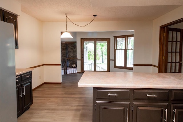 1831 E Woodbine St, Springfield, MO 65803 - kitchen featuring freestanding refrigerator, wood finished floors, light countertops, baseboards, and a textured ceiling