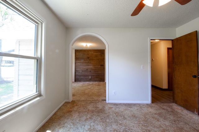 1831 E Woodbine St, Springfield, MO 65803 - carpeted spare room featuring ceiling fan, arched walkways, healthy amount of natural light, a textured ceiling, and baseboards