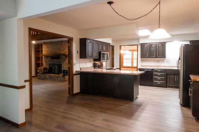 1831 E Woodbine St, Springfield, MO 65803 - kitchen with stainless steel appliances, wood finished floors, light countertops, a peninsula, and dark brown cabinetry