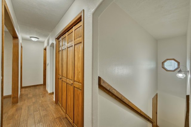 224 Loveland Dr, Rogersville, MO 65742 - corridor with light wood-type flooring, a textured ceiling, and arched walkways