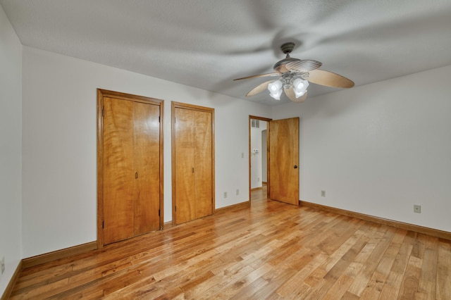 224 Loveland Dr, Rogersville, MO 65742 - unfurnished bedroom featuring two closets, light wood-type flooring, baseboards, and a ceiling fan