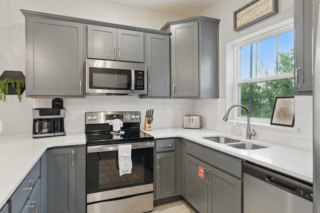 232 Chateau Mountain Hilltop Way, Branson, MO 65616 - kitchen with stainless steel appliances, gray cabinetry, a sink, backsplash, and light countertops
