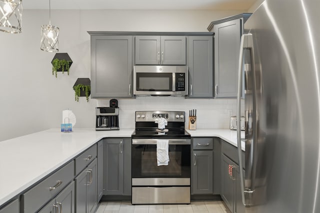 232 Chateau Mountain Hilltop Way, Branson, MO 65616 - kitchen with appliances with stainless steel finishes, gray cabinets, light countertops, decorative backsplash, and decorative light fixtures