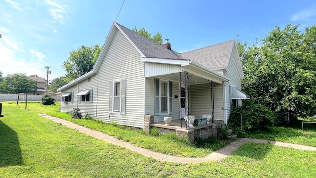 304 Frisco St, Monett, MO 65708 - view of home's exterior featuring a porch, a lawn, and a shingled roof