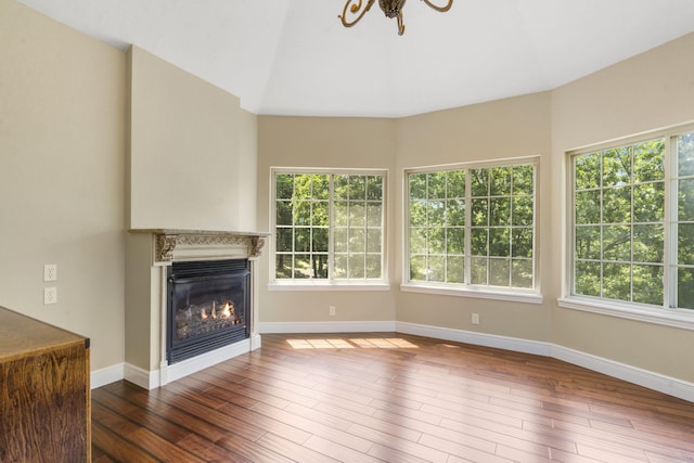 200 Barnes Ln, Branson, MO 65616 - unfurnished living room featuring a glass covered fireplace, wood finished floors, baseboards, and a chandelier