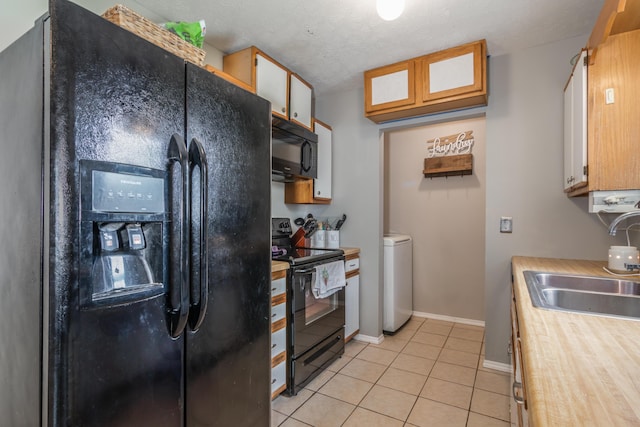 211 Spring Meadows Pkwy, Branson, MO 65616 - kitchen with black appliances, a sink, washer / dryer, light countertops, and light tile patterned flooring