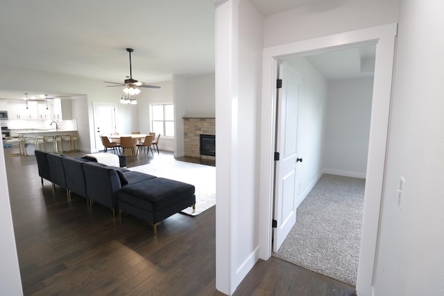 3419 S Suburban Ave, Springfield, MO 65807 - living area featuring a ceiling fan, dark wood-style floors, baseboards, and a fireplace