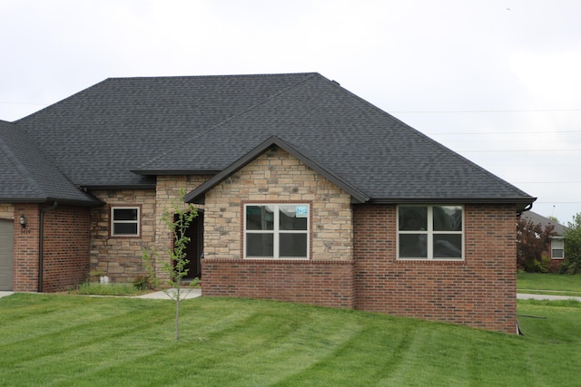 3419 S Suburban Ave, Springfield, MO 65807 - back of house with stone siding, a yard, an attached garage, and roof with shingles