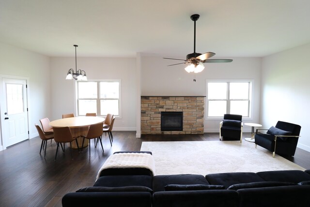 3419 S Suburban Ave, Springfield, MO 65807 - living room featuring dark wood-style flooring, a fireplace, a ceiling fan, a chandelier, and baseboards
