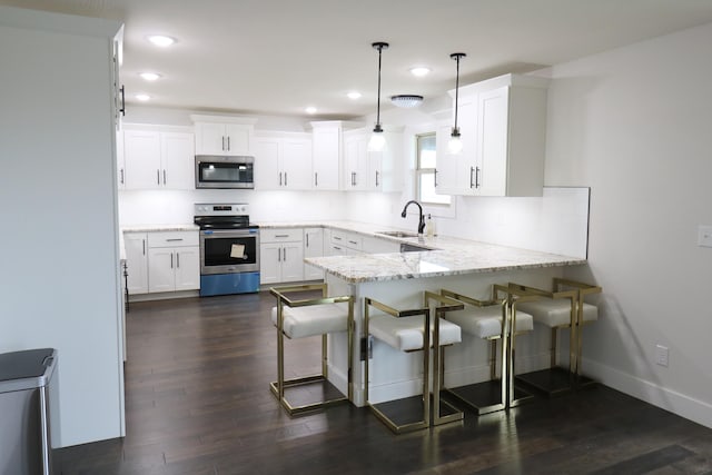 3419 S Suburban Ave, Springfield, MO 65807 - kitchen with stainless steel appliances, a sink, a peninsula, recessed lighting, and white cabinetry