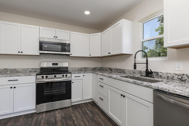 281 N 2nd St, Verona, MO 65769 - kitchen featuring stainless steel appliances, a sink, white cabinetry, dark wood-style flooring, and light stone counters