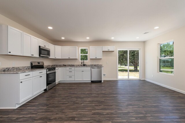281 N 2nd St, Verona, MO 65769 - kitchen with stainless steel appliances, recessed lighting, dark wood-style flooring, white cabinetry, and baseboards