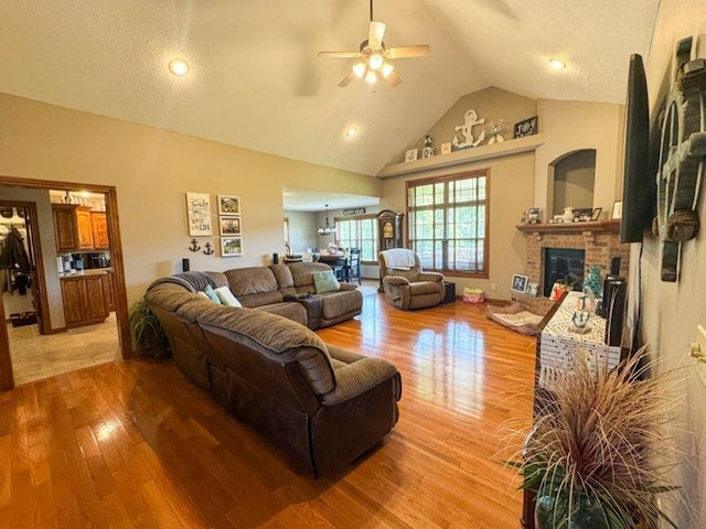 1054 W Itaska Rd, Nixa, MO 65714 - living room with light wood-type flooring, a ceiling fan, a brick fireplace, and high vaulted ceiling