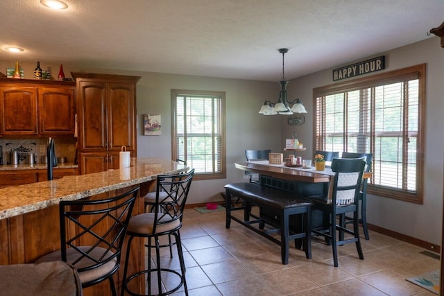 1054 W Itaska Rd, Nixa, MO 65714 - kitchen featuring baseboards, brown cabinetry, and light tile patterned floors