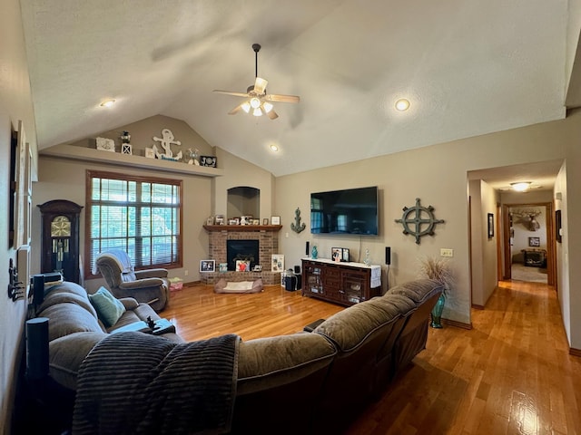 1054 W Itaska Rd, Nixa, MO 65714 - living area with ceiling fan, vaulted ceiling, a brick fireplace, wood finished floors, and baseboards