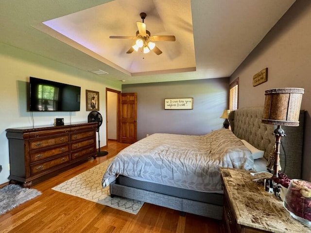 1054 W Itaska Rd, Nixa, MO 65714 - bedroom featuring a tray ceiling, wood finished floors, and a ceiling fan