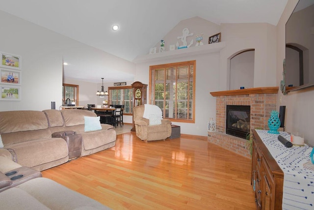 1054 W Itaska Rd, Nixa, MO 65714 - living area featuring light wood-style floors, a fireplace, lofted ceiling, a chandelier, and recessed lighting